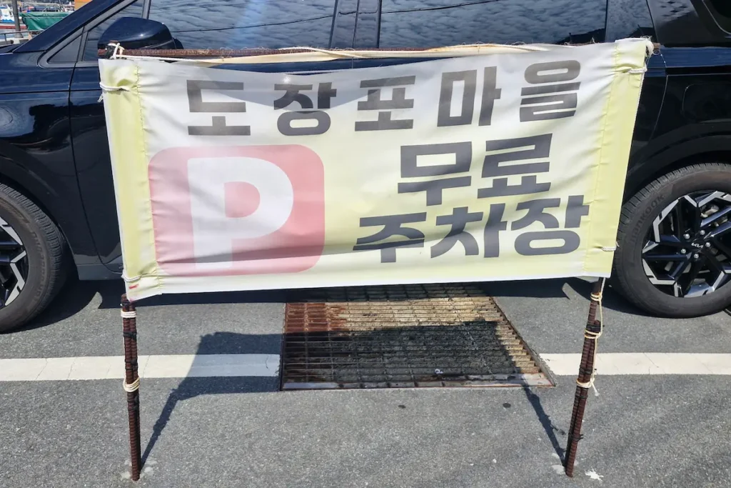 A Korean sign marking the free parking area at Dojangpo Village near Windy Hill in Geoje.