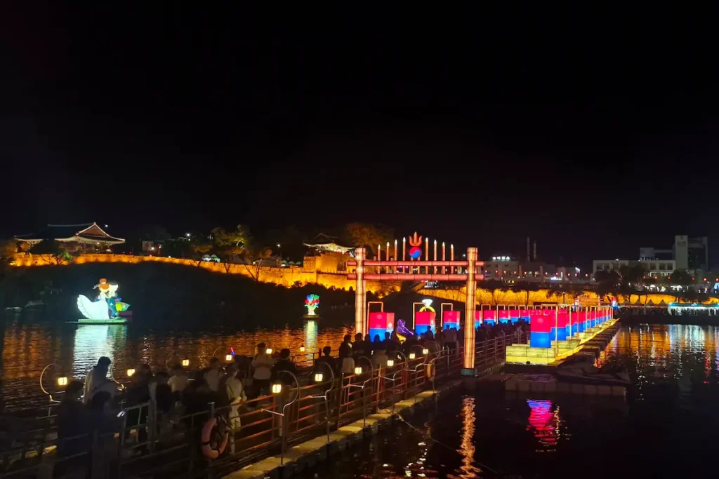 A temporary illuminated floating bridge crossing the Namgang River during the Jinju Namgang Yudeung Festival.